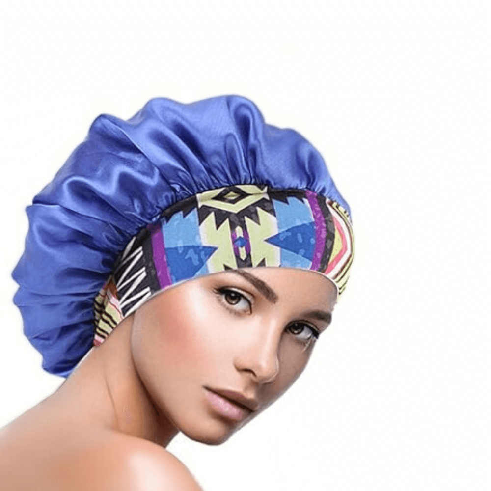 Blue Aztec satin hair bonnet with printed band worn by a woman on a white background